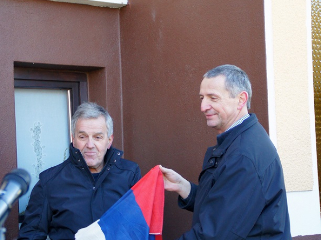 Jože Rakovec in župan Železnikov Janez Luznar odkrivata spominsko ploščo.