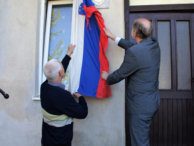 Franc Langerholc in župan Škofje Loke Miha Ješe odkrivata obeležje.